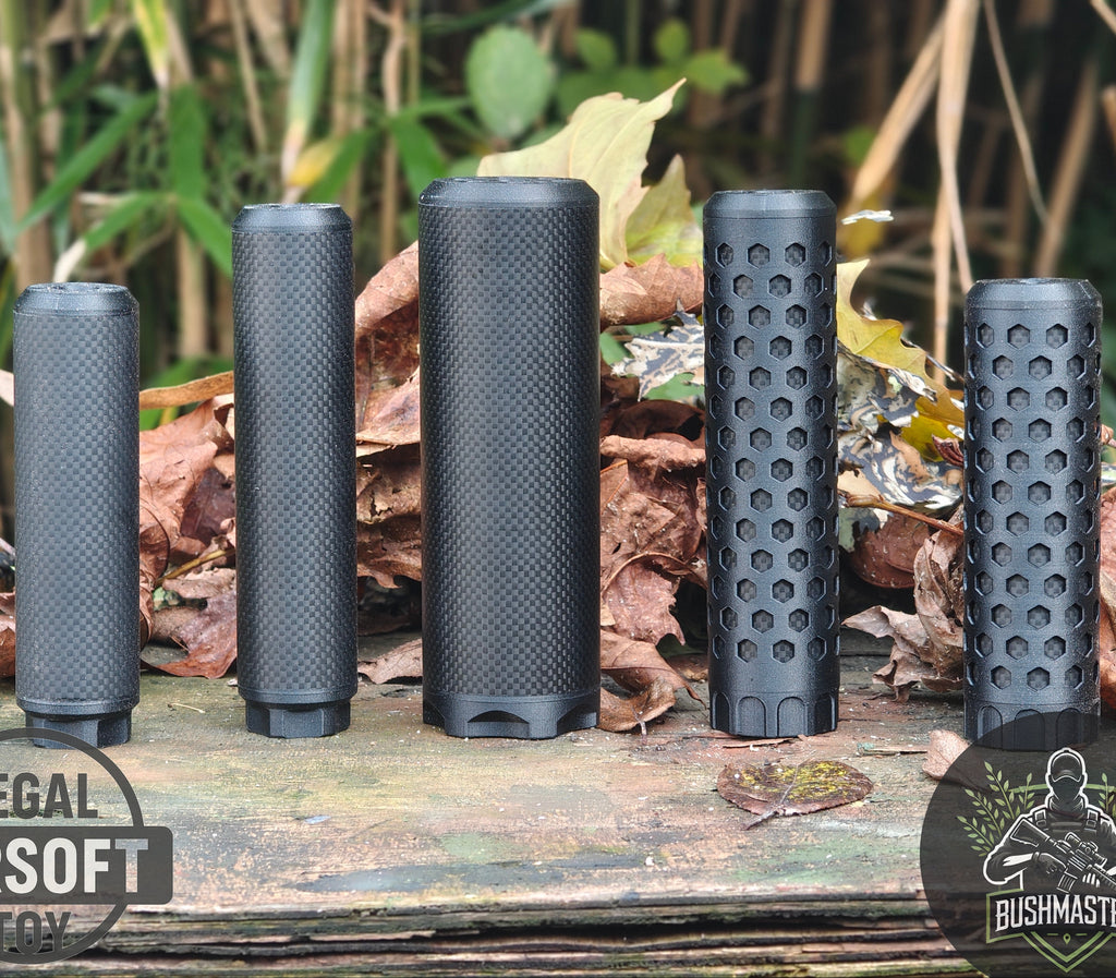 Five black cylindrical airsoft suppressors with textured and honeycomb patterns on wooden surface with dry leaves