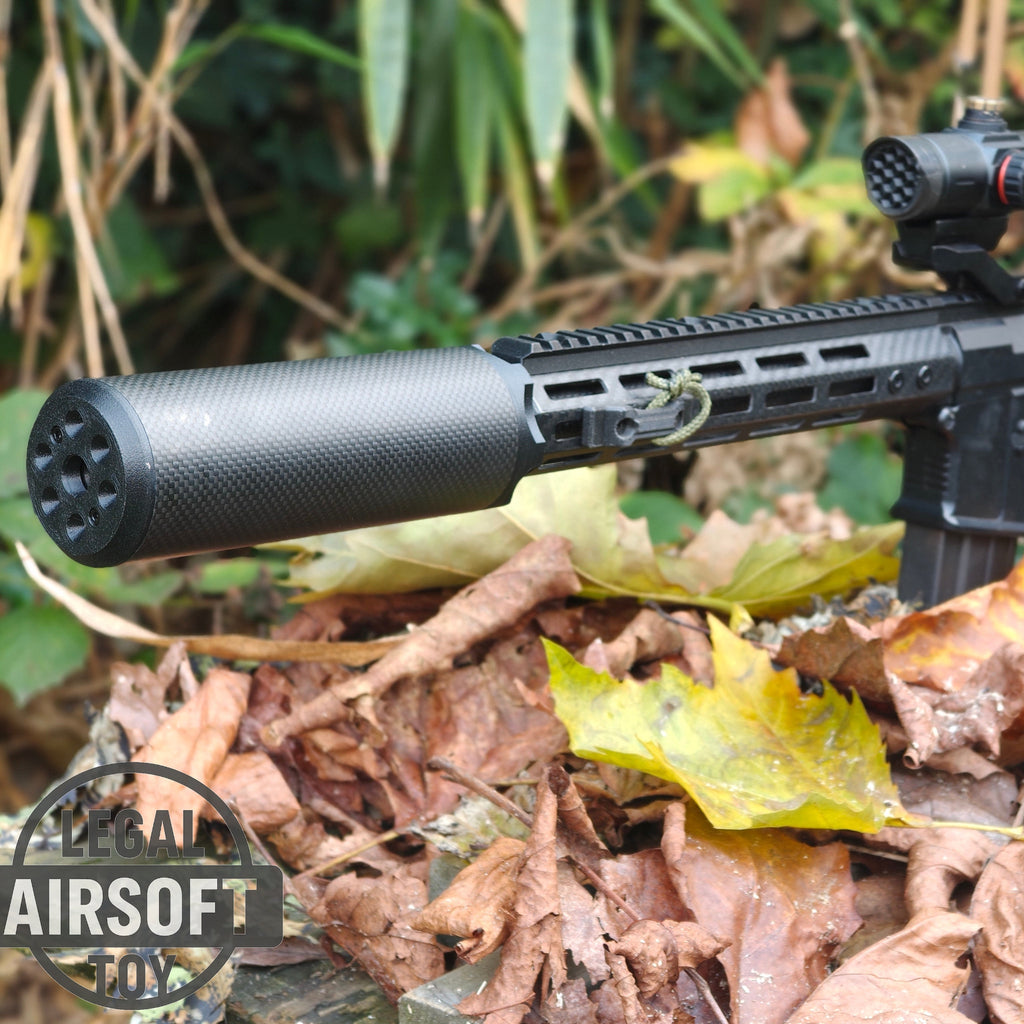 Black airsoft rifle with a suppressor lying on autumn leaves in a natural outdoor setting