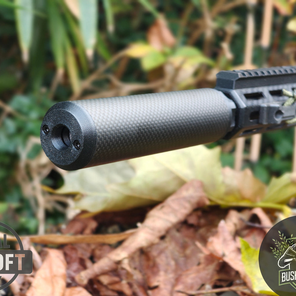 Close-up of carbon fiber suppressor attached to black tactical rifle in outdoor autumn setting