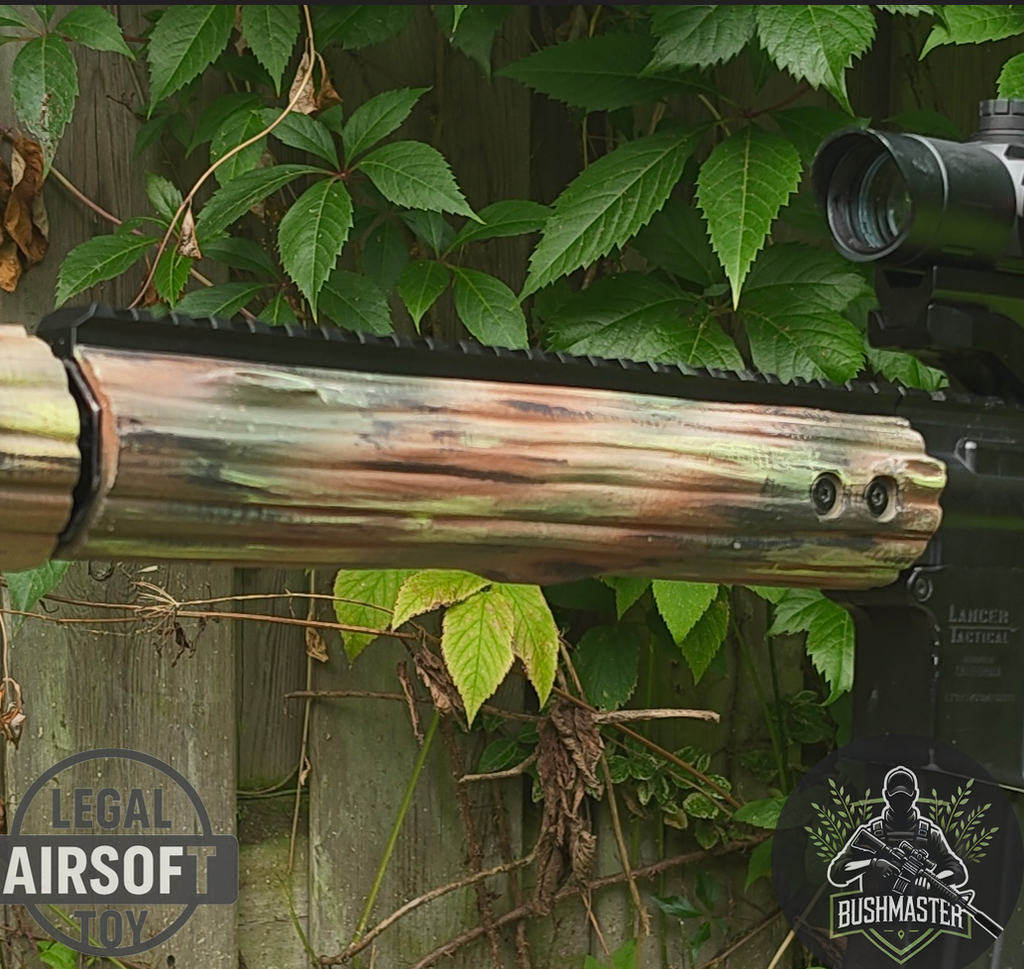 Close-up of Lancer Tactical airsoft rifle with camouflage handguard against green leaves and wooden fence