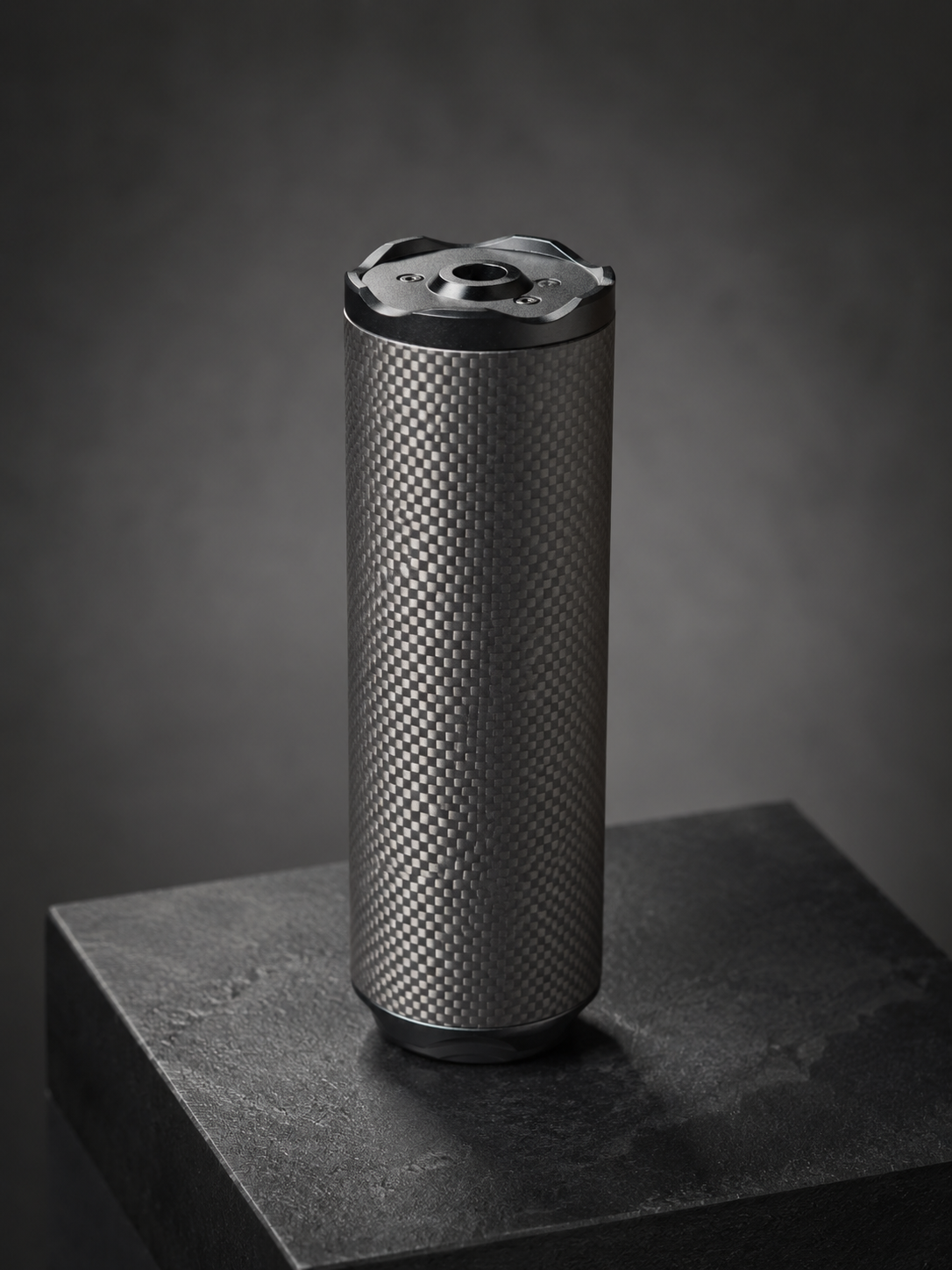 Bushmaster Big Boy Gen 3 carbon-fiber airsoft sound moderator standing on a dark display pedestal