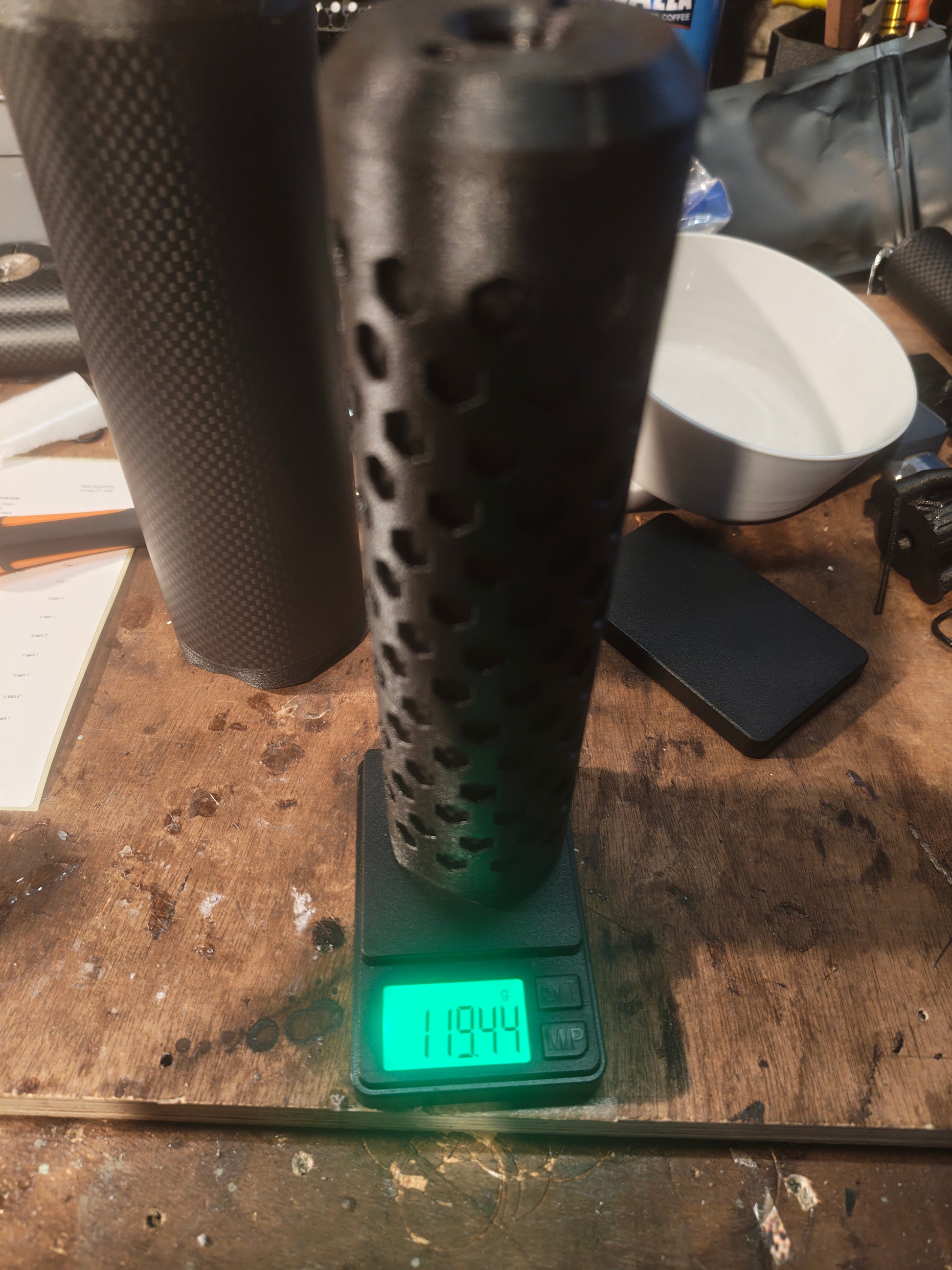 Bushmaster Model HEX sound moderator standing on a digital scale for a product weight measurement
