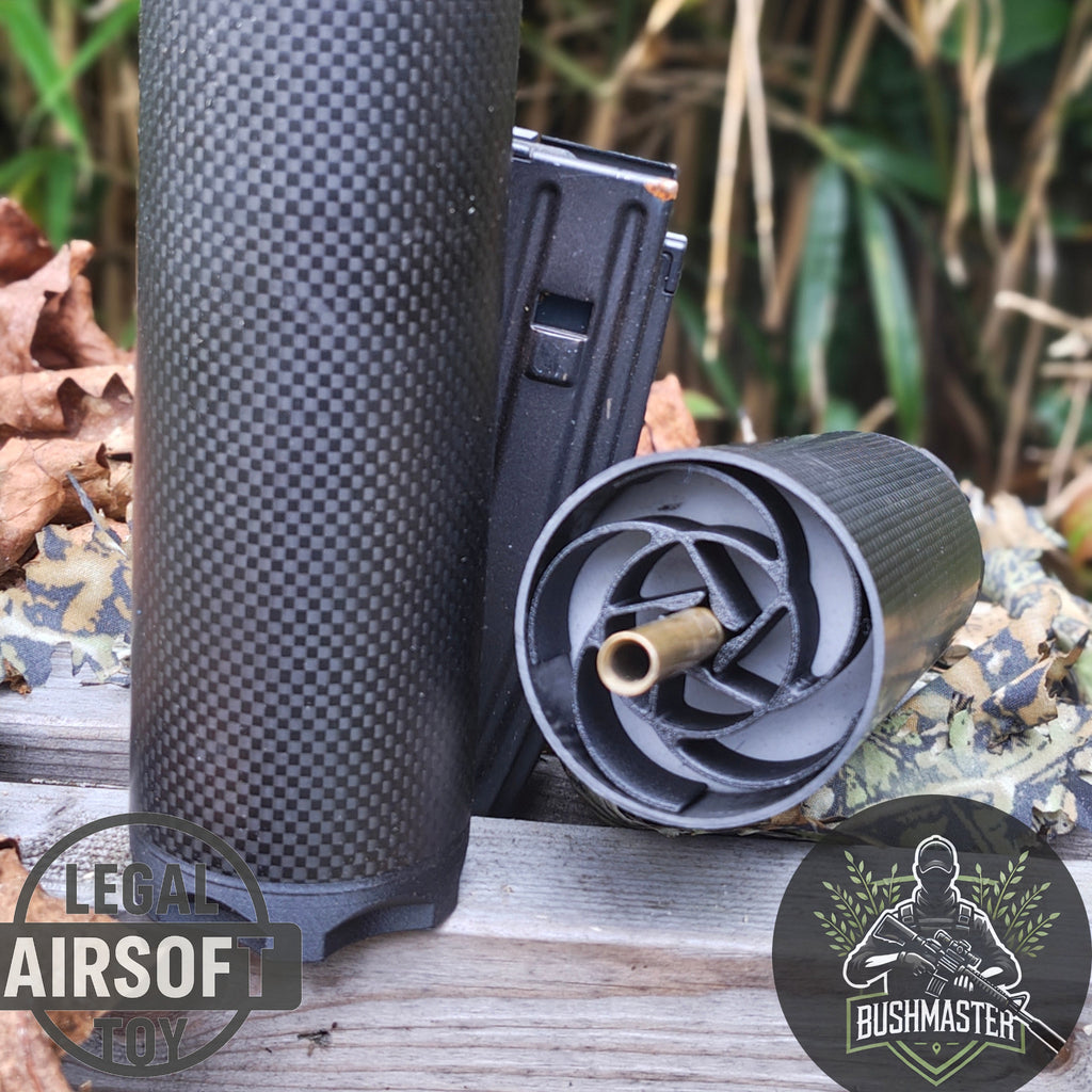 Black airsoft suppressor, magazine, and BB pellet loader on wooden surface with leaves background
